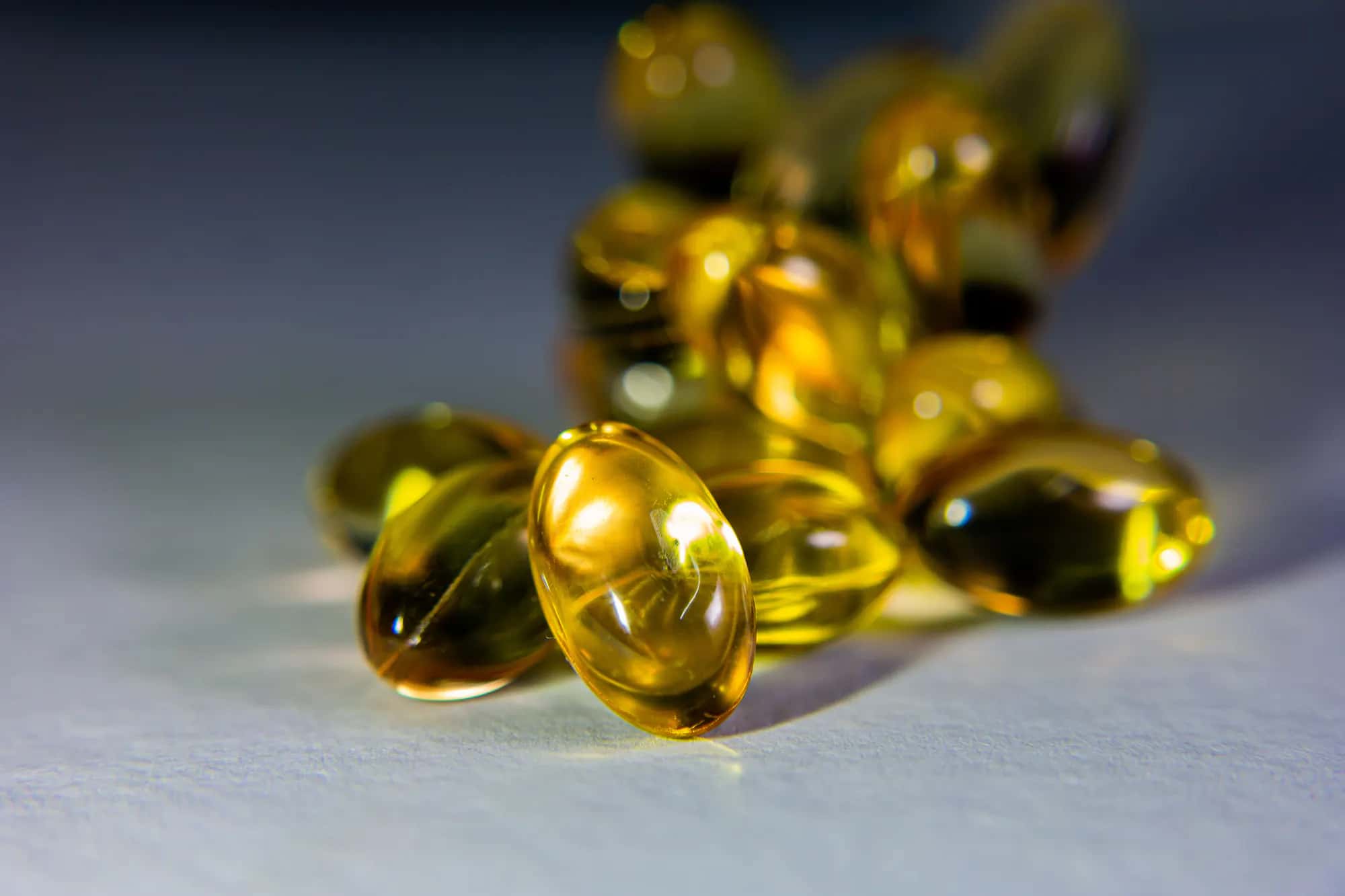 Translucent golden softgel capsules arranged on a clean surface