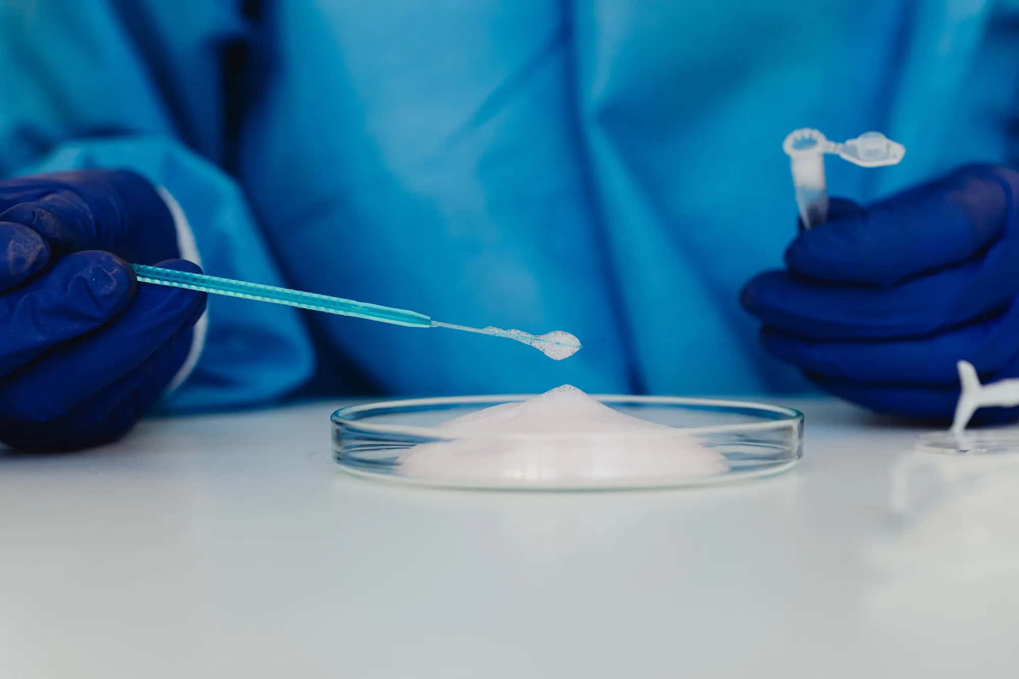 Fine pale vitamin ingredient powder on a laboratory weighing dish
